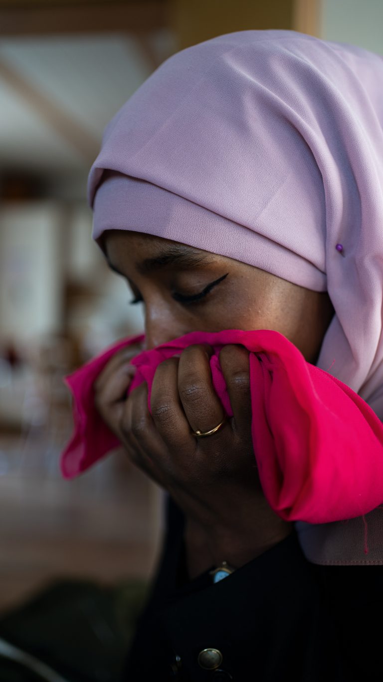 Roza Kahlid riecht an dem pinken Tuch, welches ihr einziges Erinnerungsstück an ihre Mutter ist.