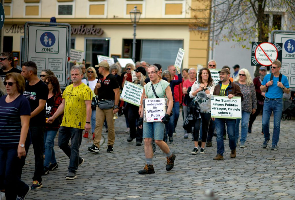 Das Bild zeigt Demonstrierende in Ansbach. Auf ihren Schildern steht "Friedensnobelpreis für Wladimir Putin" oder "Der Staat und unsere Politiker versagen, zu viele sehen zu."