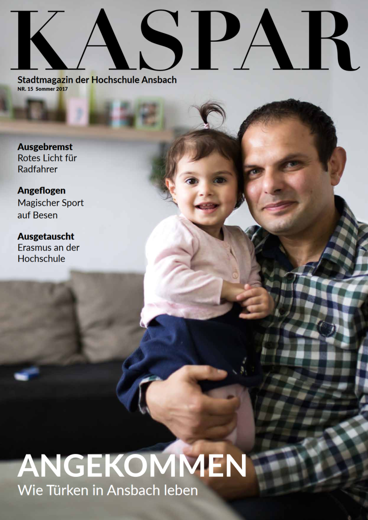 Cover Ausgabe 15: Mann mit Kleinkind auf dem Arm. Titel: "Angekommen - Wie Türken in Ansbach leben"
